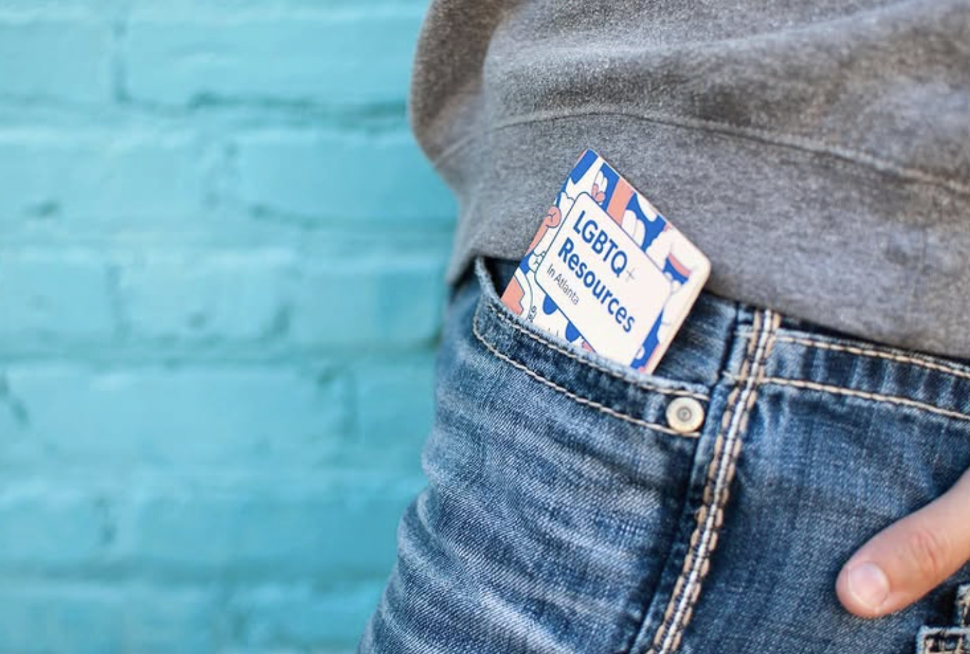 LGBTQ+ Resources pocket guide tucked into a jean pocket showing its pocket-sized design